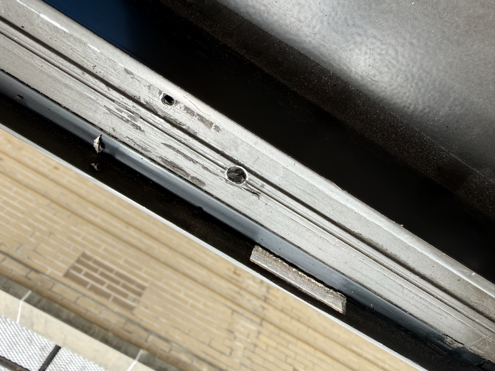 Gouged frame · exposed screw holes · debris left in the track